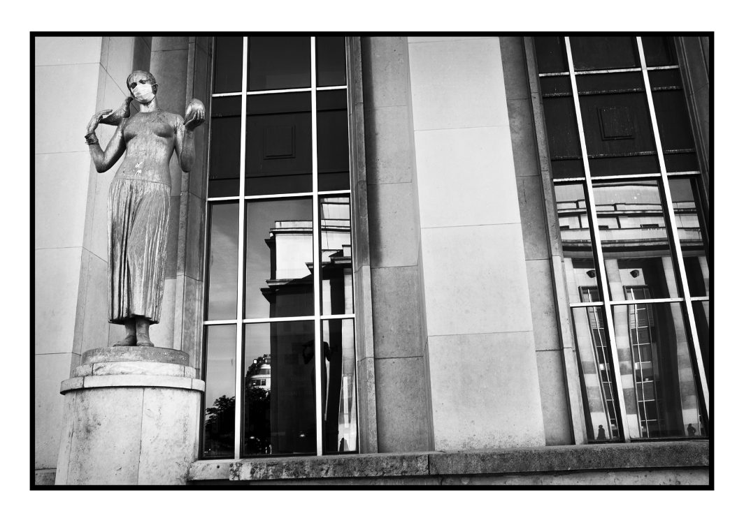 Photo, Monument, Façade, Devanture, Sculpture, Sculpture dorée, Personnage, Ombre, Trocadero, Covid, Corona Virus, Confinement, Le Pari(s) confiné, Livre, Ouvrage, Fenêtre, Baie vitrée, Reflet, Esplanade du Trocadéro, Les oiseaux, Louis Brasseur, Oiseau, Cape, Masque, Protection, Reportage, Noir et blanc, n&b, nb, Paris, France