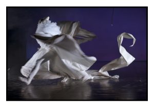 Photo, Cape, Cirque, Série, Cirque en chantier, Pentimento, Clown blanc, Scène, Personnage, Homme, Acrobate, Acrobatie, Spectacle, Chapiteau, Papier, Mouvement, Fond bleu, Collerette, Chapeau pointu, Madonna Bouglione, Reportage, Flou, Bougé, Couleur, Boulogne-Billancourt, France