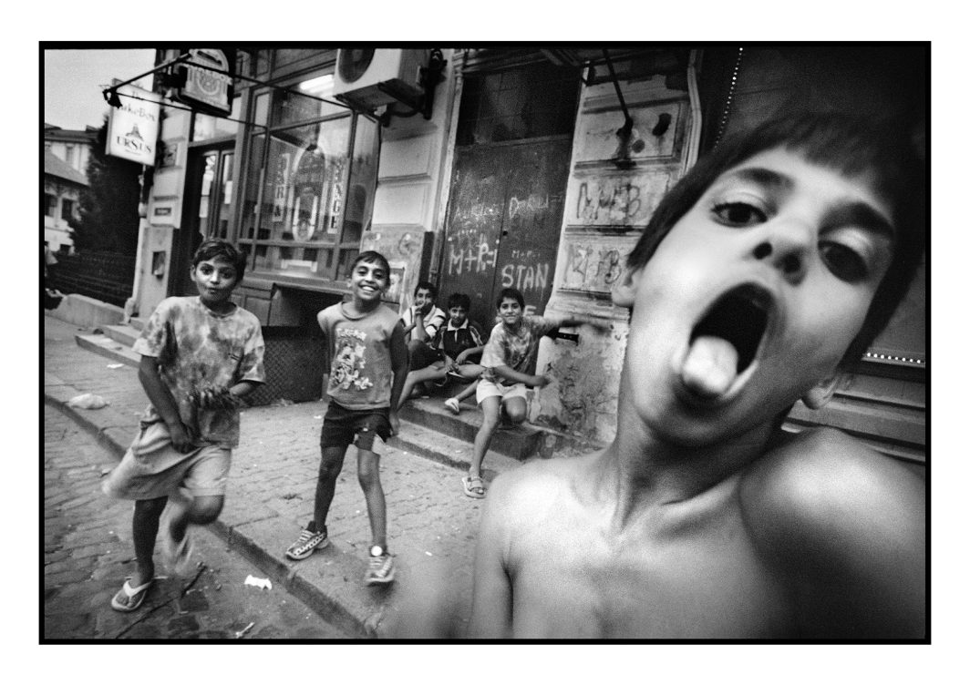 Photo, Voyage, Ville, Personnage, Roumaine, Roumain, Portrait, Visage, Enfant, Garçon, Jeu, Rire, Sourire, Immeuble, Groupe, Torse nu, Escalier, Graffitis, Flou, Magasin, Devanture, Façade, Trottoir, Rue, Regard, Langue tirée, Langue, Air conditionné, Enseigne, Extérieur, Reportage, Noir et blanc, n&b, nb, Bucarest, Roumanie