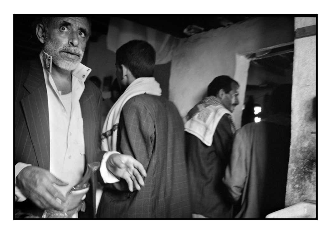 Photo, Voyage, Village, Maison, Yéménite, Personnage, Homme, Portrait, Visage, Regard, Châle, Costume, De dos, Mur, Porte, Lavabo, Jambia, Couteau, Intérieur, Reportage, Noir et blanc, n&b, nb, Yémen, Asie
